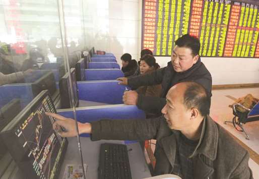 Investors look at computer screens showing stock information at a brokerage house in Fuyang. Chinese government debt is benefiting from the trade spat as stocks have fallen into a bear market and a reserve-ratio cut has boosted liquidity.