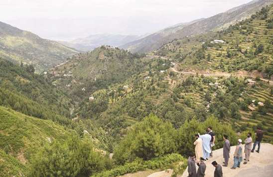 In this picture taken on May 18, officers of the Khyber Pakhtunkhwa forest department gather overlooking the forest in Swat valley in northwest Pakistan.