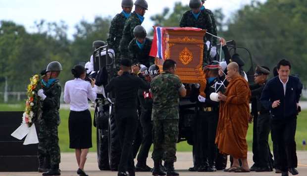 A buddhist monk leads an honour guard carrying the coffin of Samarn Poonan, 38, a former member of Thailand's elite navy SEAL unit who died working to save 12 boys and their soccer coach trapped inside a flooded cave, at Chiang Rai airport, Thailand.
