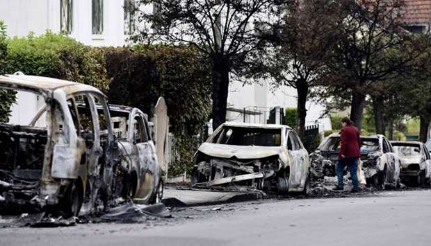 A resident looks at the wreckage of burnt-out cars in the Bellevue neighborhood in Nantes