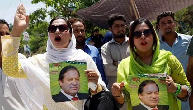 Supporters of Pakistan Muslim League (Nawaz) hold his pictures as they chant slogans to condemn the verdict on an anti-corruption case against ousted prime minister Nawaz Sharif and his daughter, during a protest in Islamabad on Friday.