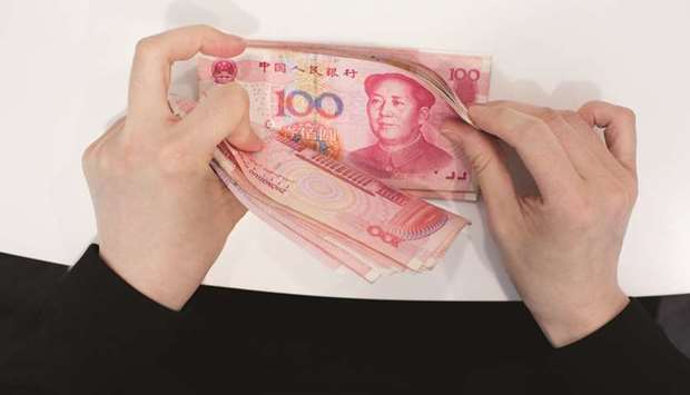 A Standard Chartered employee counts yuan banknotes in an arranged photograph in Hong Kong. The yuanu2019s one-month implied volatility shows traders are pricing in the prospect of larger swings in the currency, but the metric has been higher than current levels several times over the past few years.