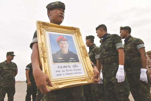 A soldier carries a portrait of Saman Gunan at a military base in Chon Buri province  yesterday.