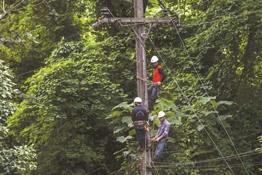 Workers set up the electric cable near the Tham Luang cave in the Mae Sai district of Chiang Rai province yesterday.