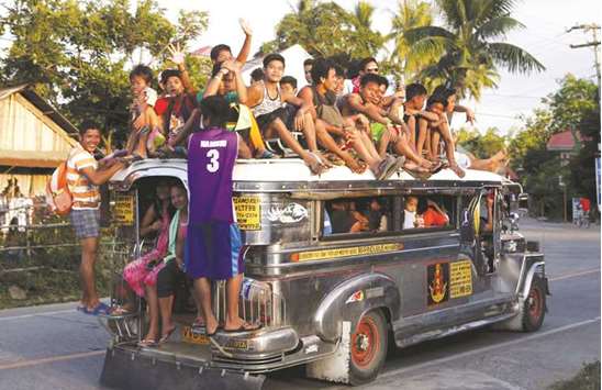 File photo shows residents ride on top of an overcrowded u201cjeepney,u201d along a highway in Mogpog town on Marinduque island in central Philippines.