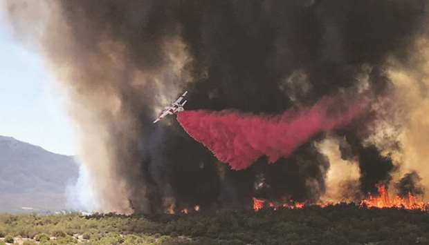 An air tanker drops fire retardant on a wildfire called the u2018BentonFireu2019, off Benton Road and Crams Corner Drive, in this image taken on Wednesday from social media in Anza, Riverside County, California.