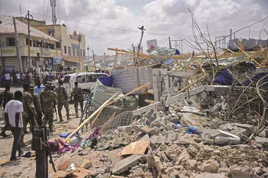 Somali security force personnel walk among debris at the site of a car bomb explosion near the building of the Interior Ministry in Mogadishu yesterday.
