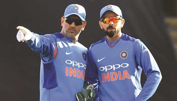 Indiau2019s MS Dhoni (left) and captain Virat Kohli discuss field placings during the Twenty20 match against England at Sophia Gardens in Cardiff, south Wales, on Friday. (AFP)