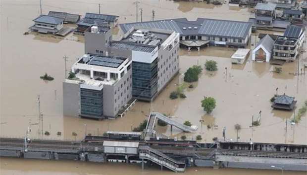 An aerial view of flooded houses and a railway station (bottom) in Kurashiki on Sunday.