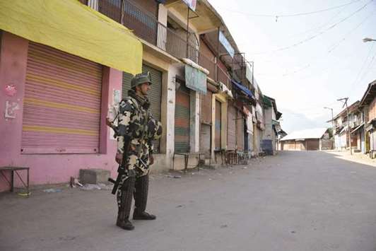 A trooper patrols a deserted street during a protest called by separatists to mark the second death anniversary of Hizbul commander Burhan Wani, in Tral yesterday.