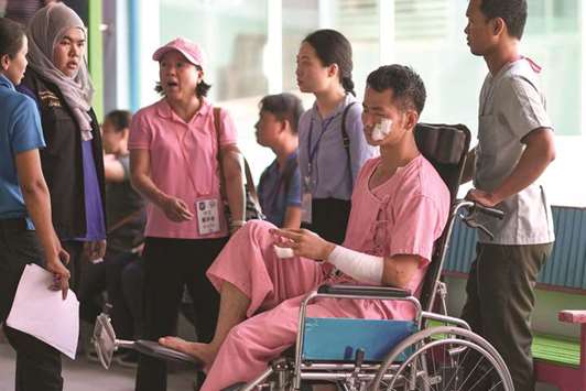 Huang Junxiong, a Chinese survivor, sits in a wheelchair at the Vachira Phuket Hospital in Phuket yesterday, after a tourist boat carrying 105 passengers, mostly Chinese tourists, capsized in rough seas on July 5.
