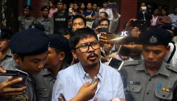 Detained Myanmar journalist Wa Lone speaks to reporters as he is escorted by police from a courthouse following his ongoing pre-trial hearing in Yangon on Monday.