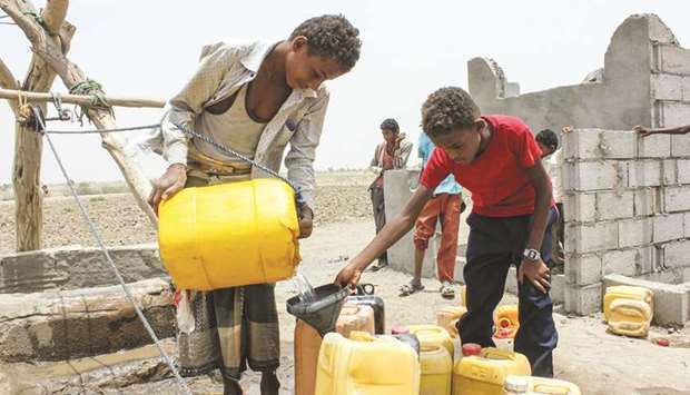 A boy displaced from the eastern Yemeni district of Durahemi pours water drawn from a well into jerry cans near the Red Sea port city of Hodeidah, yesterday.
