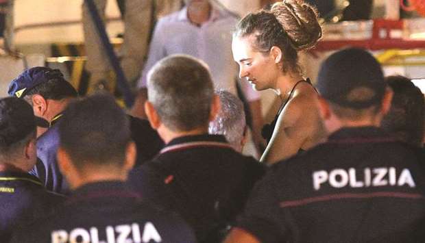 This picture taken on Saturday shows Rackete being escorted off her ship by police officers.
