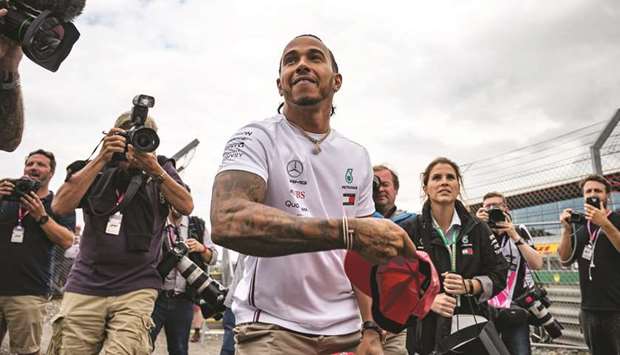 Mercedesu2019 British driver Lewis Hamilton throws signed caps to his fans at Silverstone motor racing circuit in Silverstone, central England, yesterday.