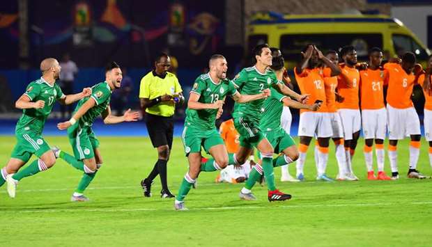 Algerian players celebrate after winning the Africa Cup of Nations quarter-final match even as Ivory Coast players look dejected at the Suez stadium in Suez, Egypt, yesterday. (AFP)