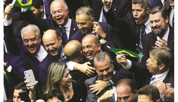 Members of Congress and supporters of the pension reform bill, celebrate the vote at the plenary session of the Chamber of Deputies in Brasilia, Brazil.