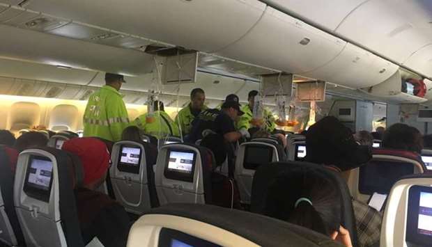 Emergency workers assist passengers of Air Canada AC 33 flight, which diverted to Hawaii after turbulence, at Honolulu airport, Hawaii