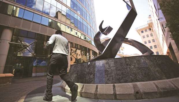 An employee passes the sculpture outside the stock exchange in Johannesburg, South Africa.