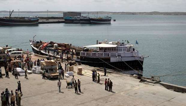 Workers stand at the sea port of the coastal town of Kismayu in southern Somalia. November 12, 2013 file picture