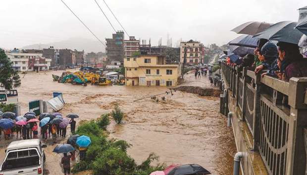 Residents look at floodwaters after the Balkhu River overflowed following monsoon rains at the Kalanki area of Kathmandu yesterday.