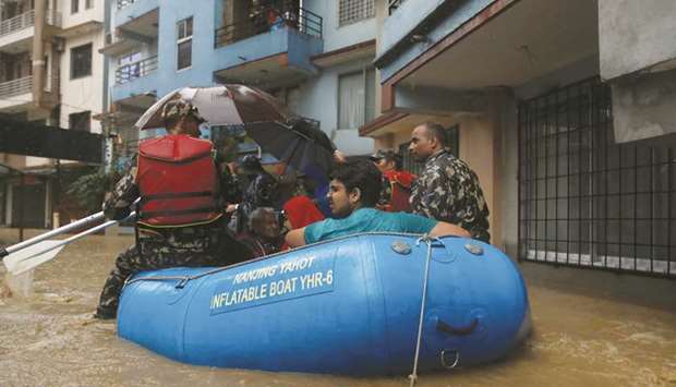 Residents are carried out on a boat in a flooded colony in Kathmandu yesterday.