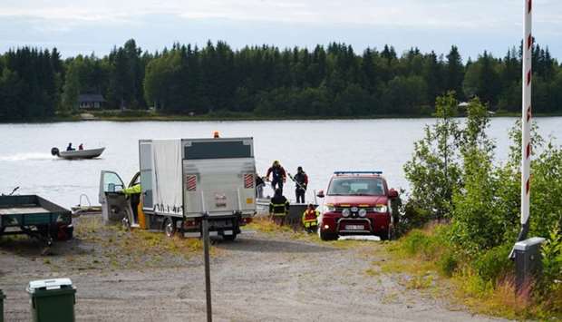 An emergency services boat carrying wreckage parts arrives at a harbour near the site, where a small sports aircraft with nine people on board has crashed at Ume river outside Umea, Sweden