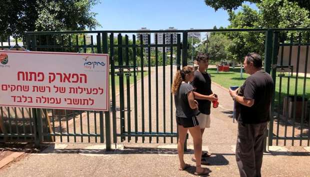 A security guard checks the identification of visitors near the entrance to a park in the northern Israeli town of Afula