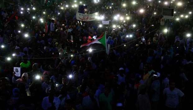 Sudanese protesters take part in a vigil in the capital Khartoum's northern district of Bahri, to mourn dozens of demonstrators killed last month in a brutal raid on a Khartoum sit-in yesterday.
