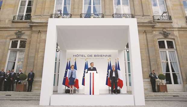 Macron delivering a speech, next to French Defence Minister Florence Parly (left) and French Junior Defence Minister Genevieve Darrieussecq, at the residence of French Defence Ministry on the eve of Bastille Day, in Paris.