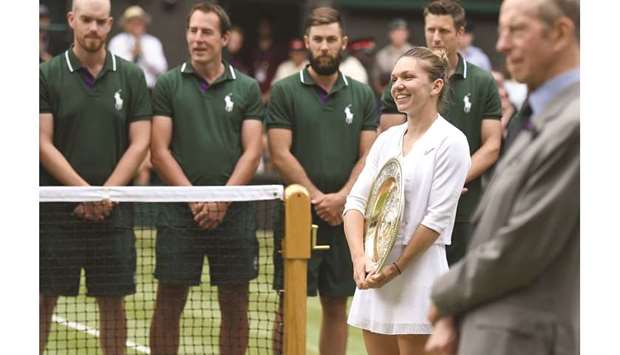 Romaniau2019s Simona Halep holds the Venus Rosewater Dish trophy during the presentation after beating US player Serena Williams in the Wimbledon final on Saturday.