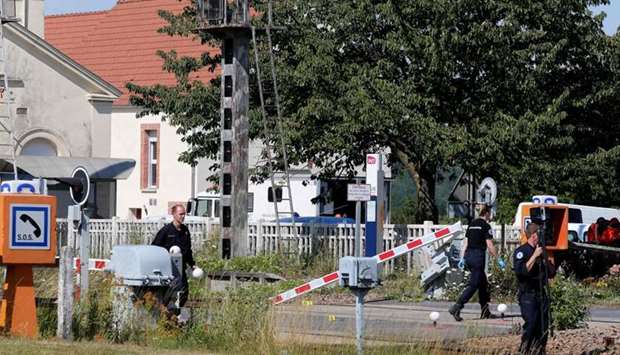 French gendarmes stand at a level crossing, after a car and a TER regional express train crashed at the exit of the train station in Avenay-Val-d'Or, near Reims, northeastern France