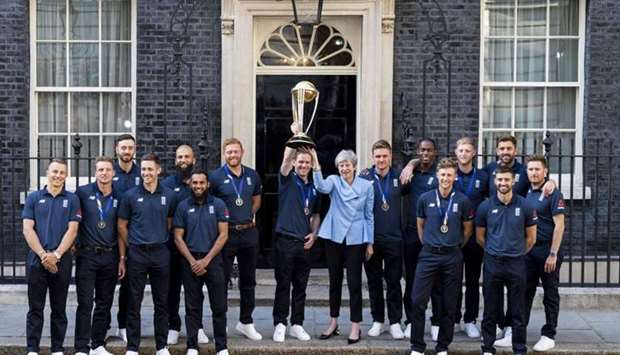 (L-R) England's Tom Curran, England's Jos Buttler, England's James Vince, England's Chris Woakes, England's Moeen Ali, England's Adil Rashid, England's Jonny Bairstow, England's captain Eoin Morgan, Britain's Prime Minister Theresa May, England's Jason Roy, England's Jofra Archer, England's Joe Root, England's Ben Stokes, England's Mark Wood, England's Liam Plunkett and England's Liam Dawson pose for a photograph outside 10 Downing Street with the World Cup trophy as England players arrive for a reception in London. AFP