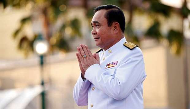 Thailand's Prime Minister Prayuth Chan-ocha greets people as he arrives for a photo session with the government cabinet in Bangkok