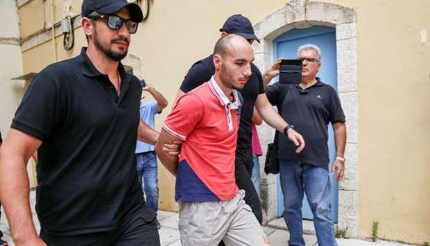 Plain-clothes police officers escort the suspect (C) for the murder of American biologist Suzanne Eaton to the prosecutor in Chania, on the island of Crete, Greece.