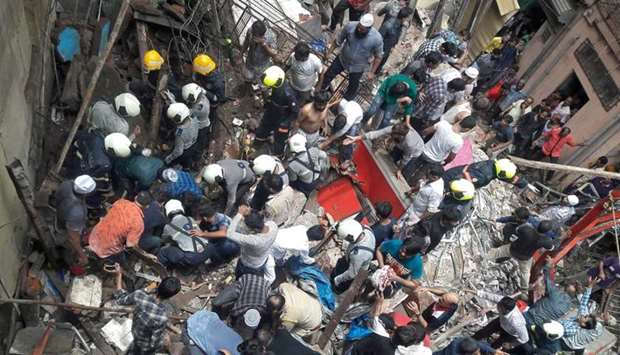 Rescue workers and residents search for survivors at the site of a collapsed building in Mumbai