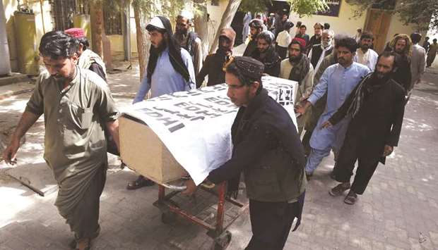 Relatives carry the coffin of a coal miner at a hospital in Quetta.