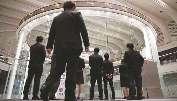 Visitors watch share prices at the Tokyo Stock Exchange. The Nikkei 225 closed down 0.3% to 21,469.18 points yesterday.