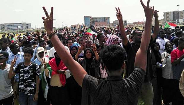 Sudanese protesters chant slogans and wave national flags as they march in the capital Khartoum's Green Square.