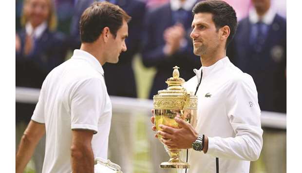 Novak Djokovic (right) holds the winneru2019s trophy after his win over Roger Federer in the Wimbledon final. (AFP)