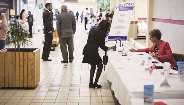 A job seeker (centre) takes a business card at a resource fair in Belmont, New Hampshire, US (file).