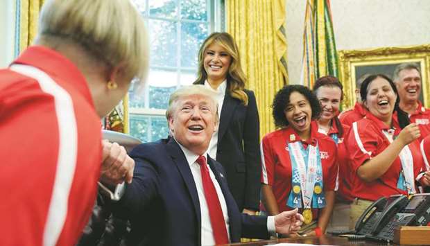 President Donald Trump reaches out to a member of Team USA for the 2019 Special Olympics World Games in the Oval Office of the White House in Washington yesterday.
