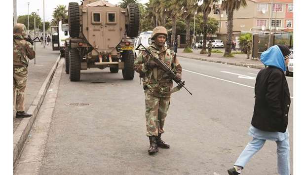 South African soldiers patrol a street in the Manenberg suburb of Cape Town yesterday.