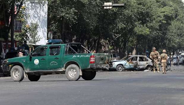 Members of Afghan security forces inspect the site of a blast near Kabul University in Kabul