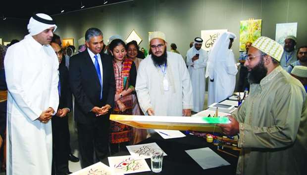 An Indian artist showing his work to Saif Saeed al-Dosari, P Kumaran and other dignitaries.  PICTURES: Jayaram