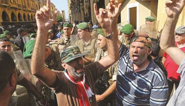 Veterans shout slogans during a protest against any cuts to their benefits in the state budget, at downtown Beirut yesterday.