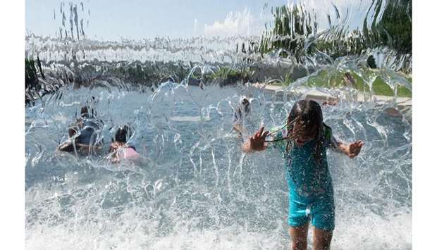 Children play in a waterfall at Yards Park in Washington, DC, yesterday as an extreme heat wave hits the region.