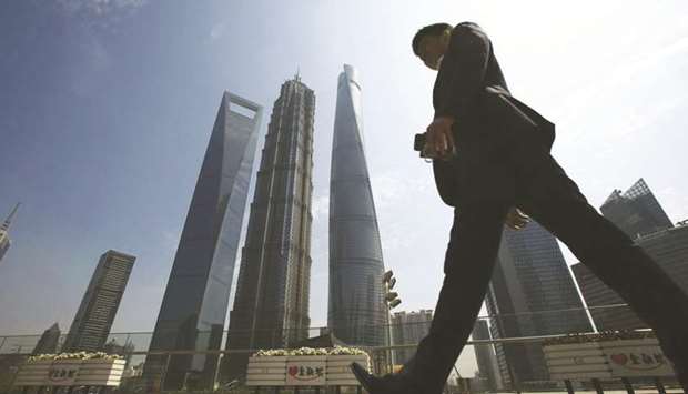 A man walks past the Shanghai World Financial Centre.