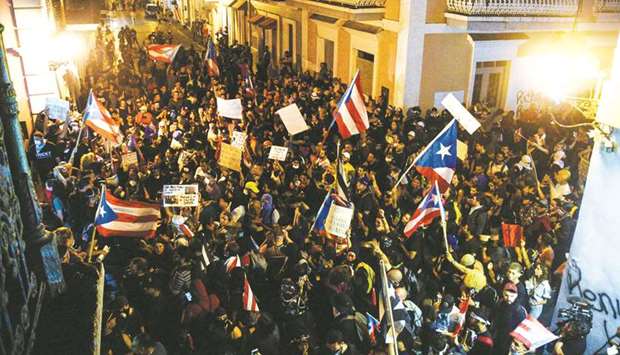 Demonstrators chant slogans as they wave Puerto Rican flags during the seventh day of protest calling for the resignation of Governor Ricardo Rossello in San Juan.