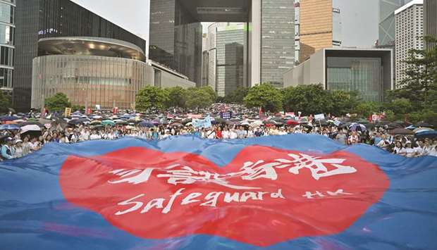 People wave a large banner that reads u201csafeguard Hong Kongu201d during a pro-government rally outside the government headquarters in Hong Kong yesterday.